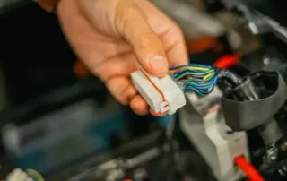 Technician connecting automotive electrical wiring harness