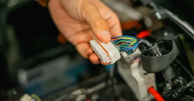Technician connecting automotive electrical wiring harness