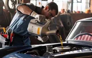 mechanic pouring engine oil into a car engine during an oil change service in auto repair workshop